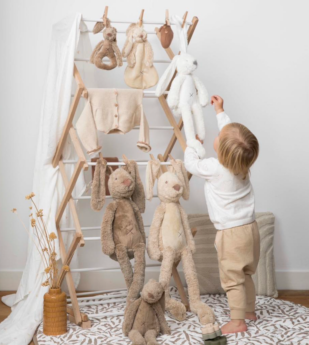 Happy Horse soft bunny plush toys displayed on a wooden play gym with toddler in neutral nursery setting