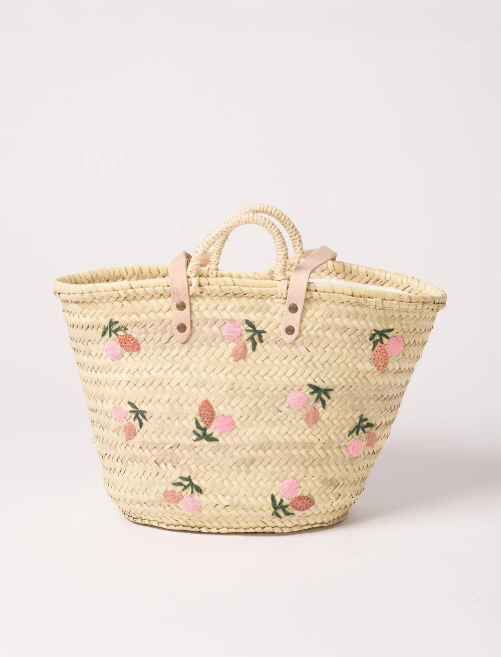 Handwoven straw beach basket with embroidered fruit details and leather handles