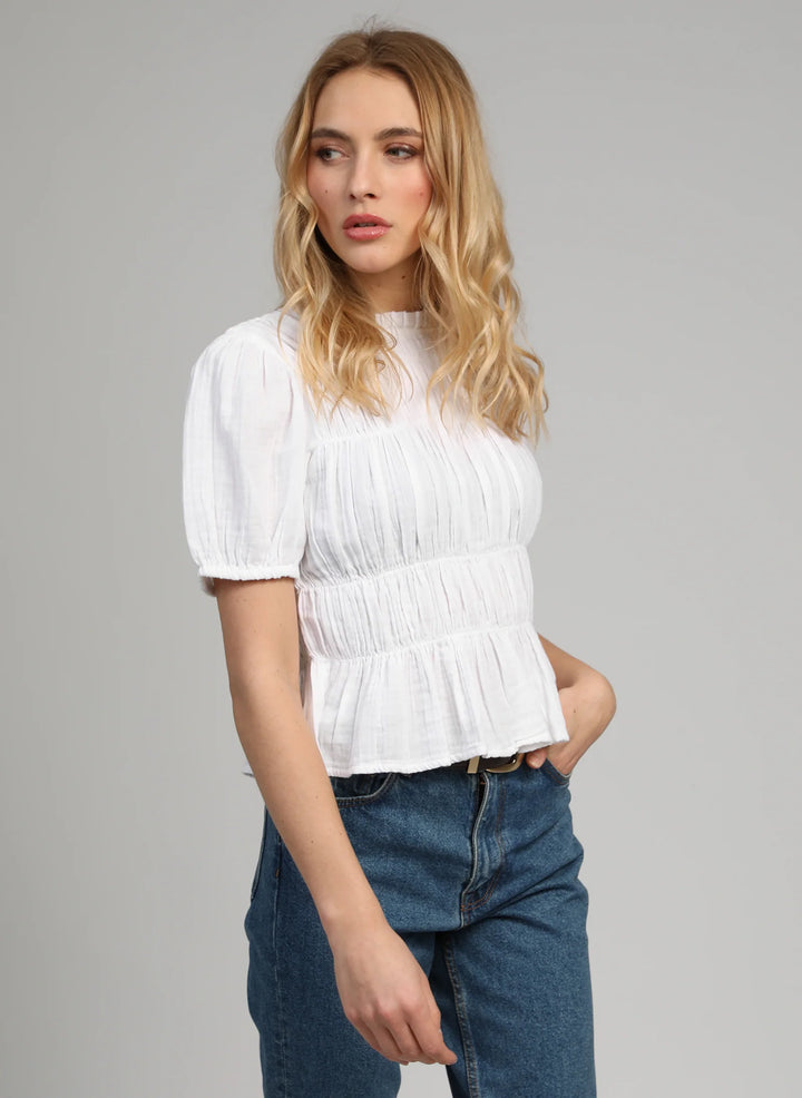 An’ge Sizaya smocked top with puff sleeves and peplum hem in lightweight textured fabric