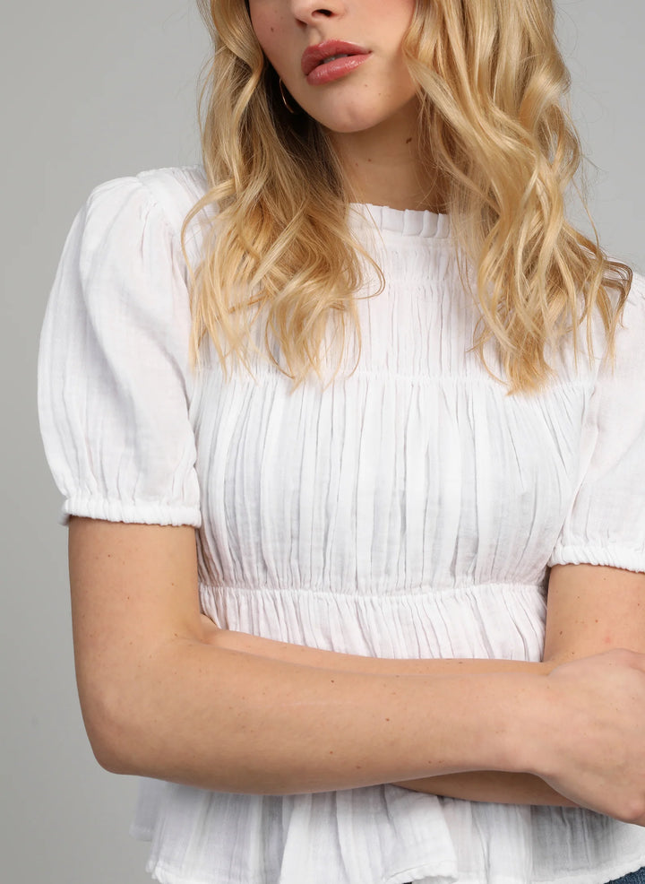 An’ge Sizaya smocked top with puff sleeves and peplum hem in lightweight textured fabric