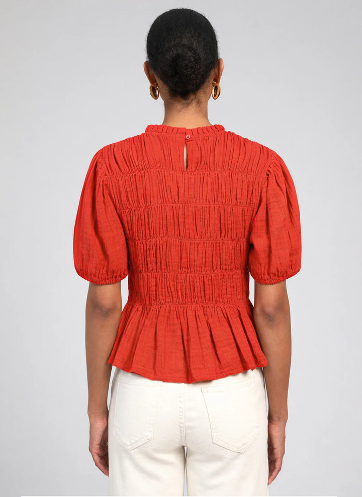 An’ge Sizaya smocked top with puff sleeves and peplum hem in lightweight textured fabric