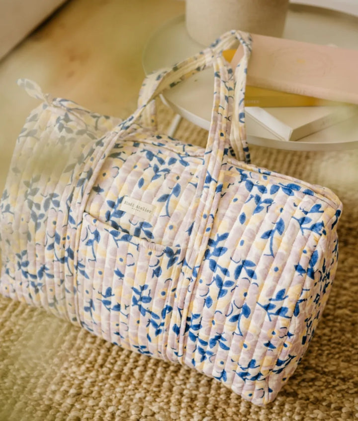 Blue floral quilted cotton weekender bag with soft padded handles and spacious travel design