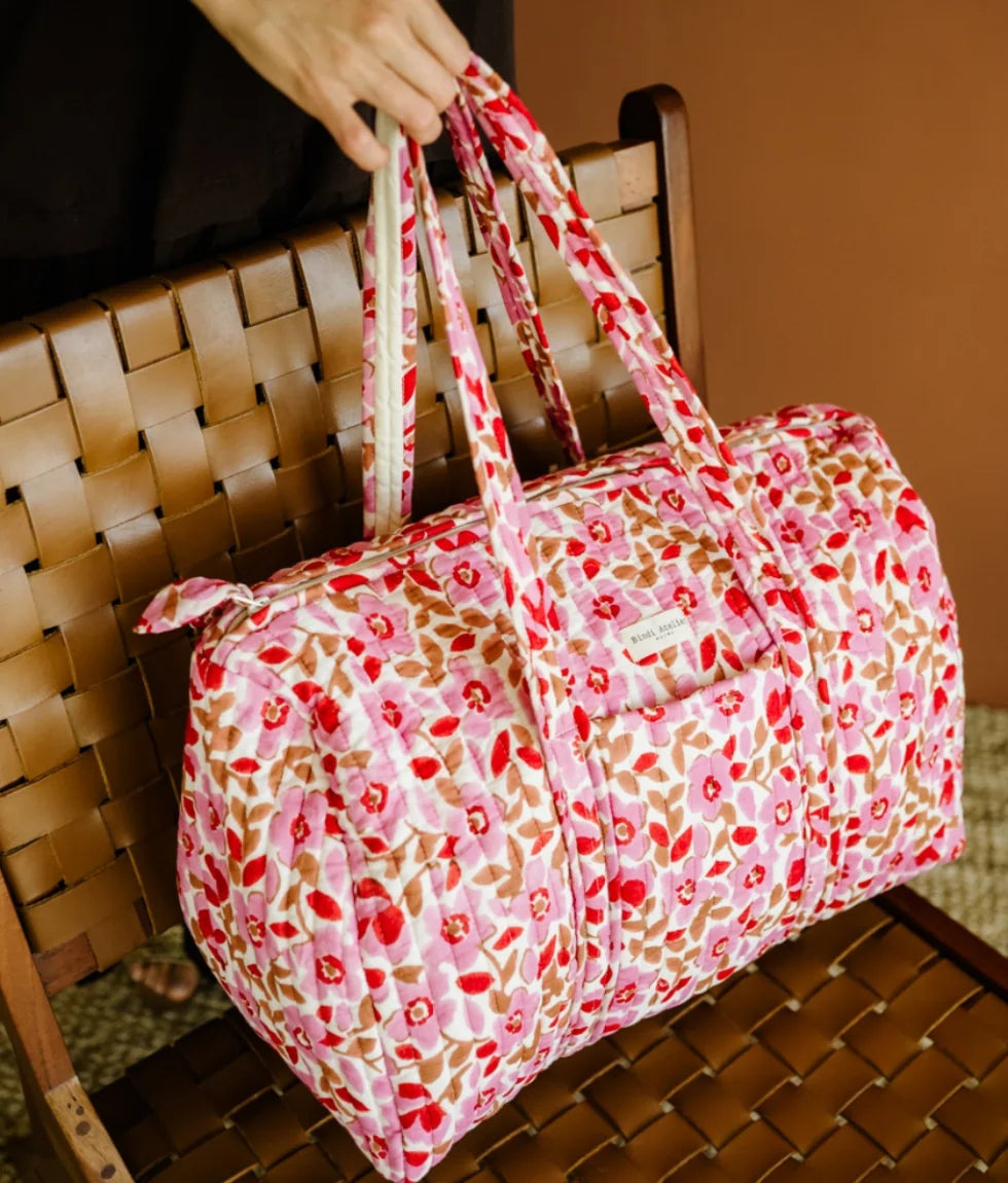 Pink floral quilted cotton weekender bag with padded handles and spacious travel design