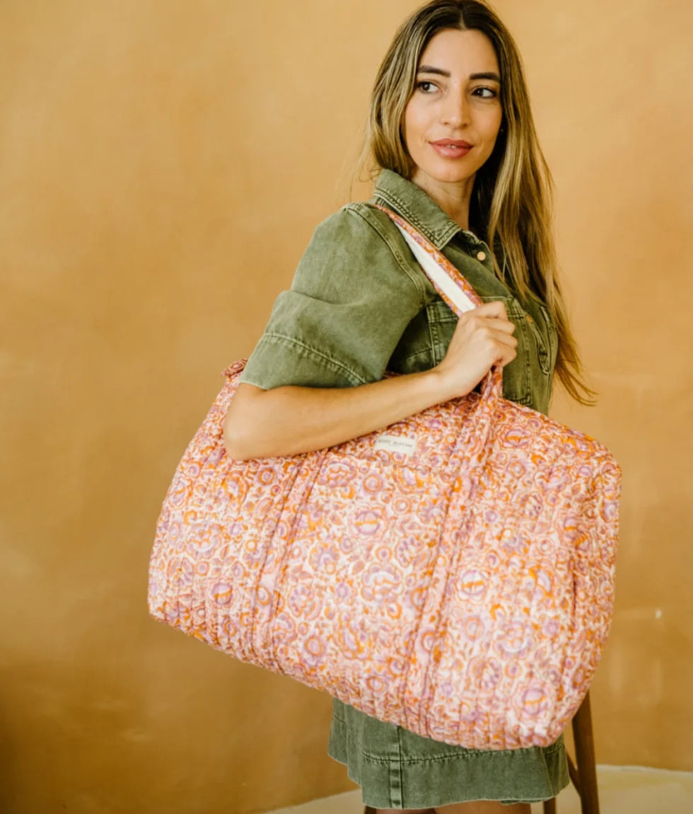 Pink floral quilted cotton weekender bag with padded handles and spacious overnight design