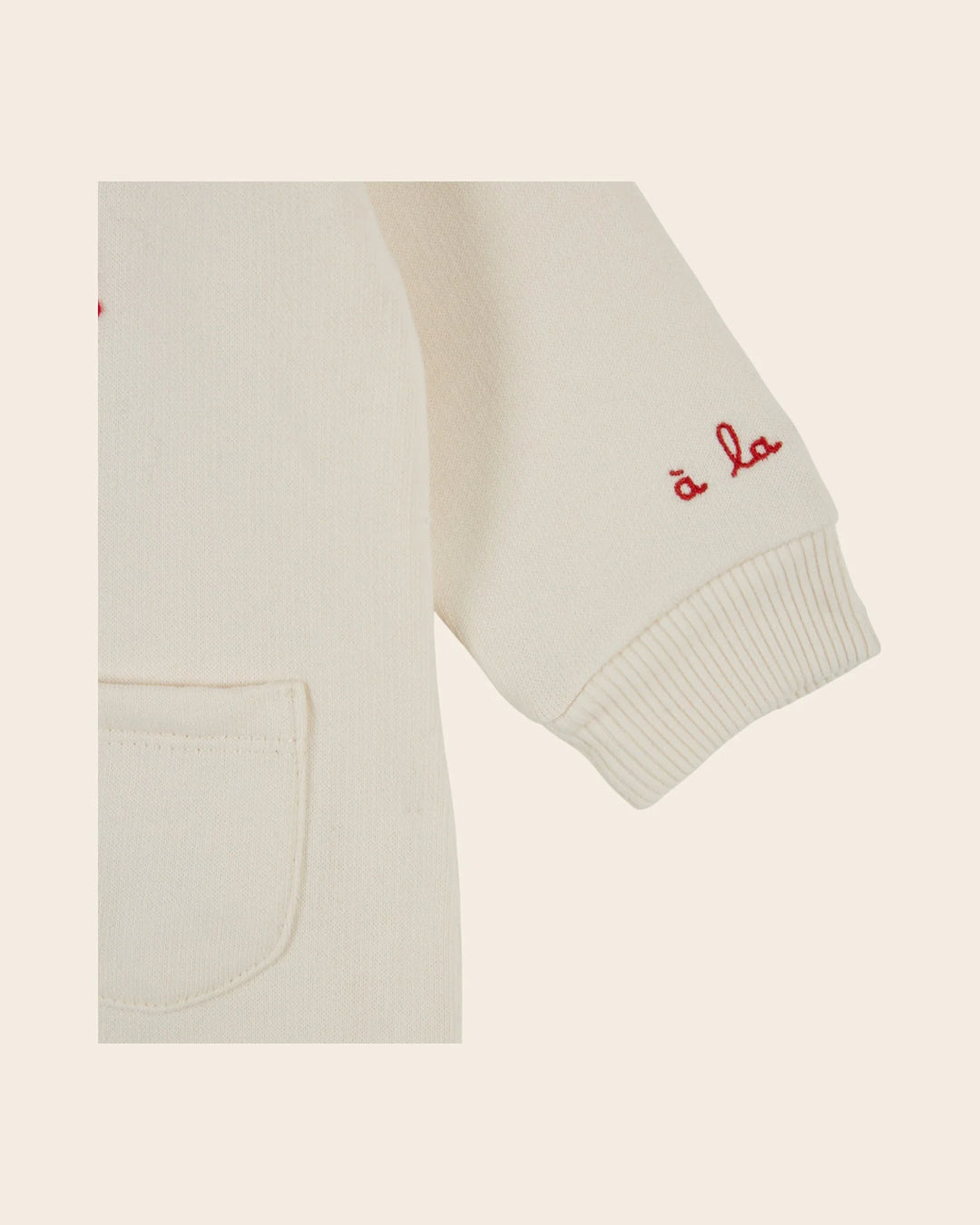 Close-up of the Emile et Ida Petit Chou baby romper in ecru, highlighting the fabric and delicate design details.