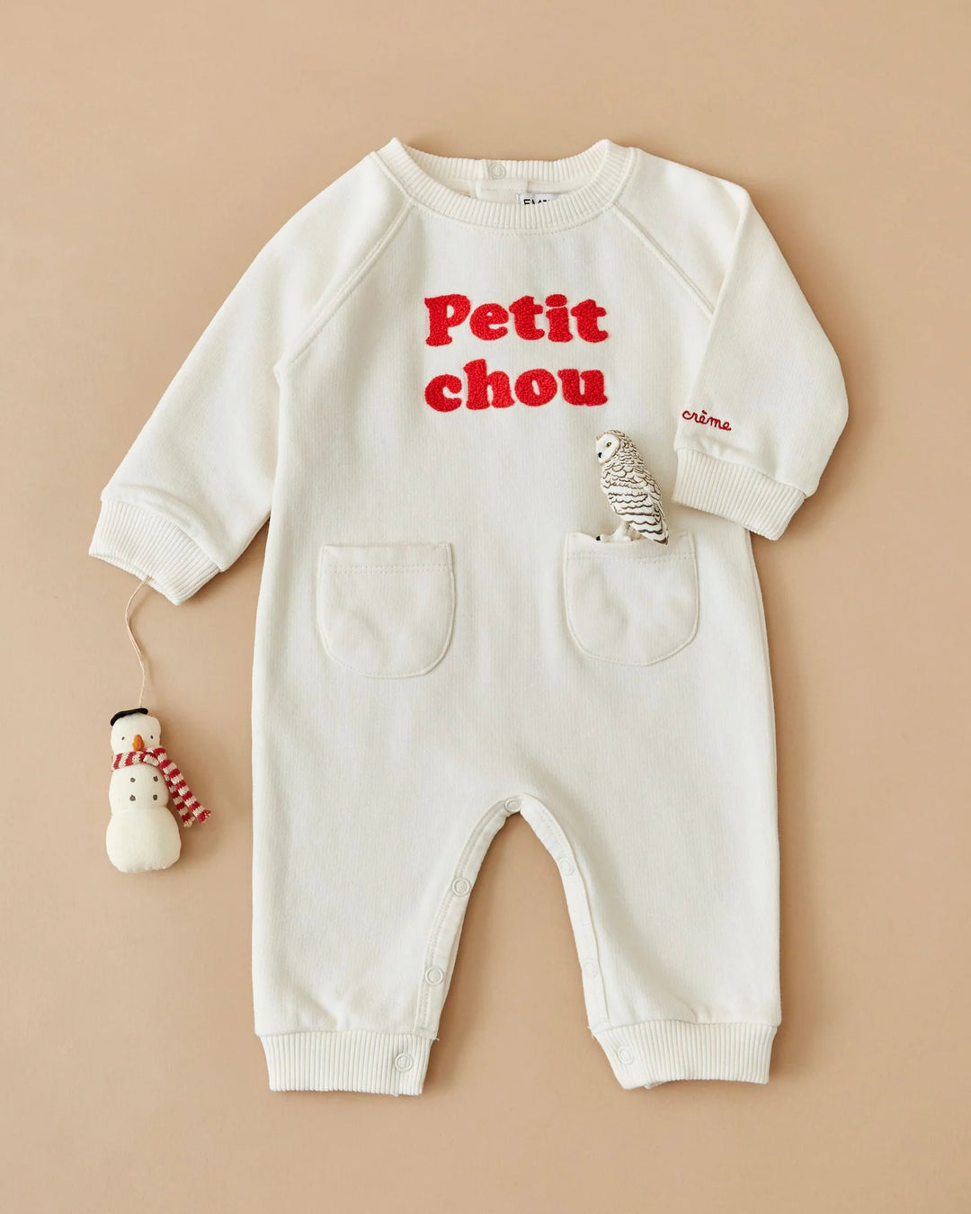 Close-up of the Emile et Ida Petit Chou baby romper in ecru, highlighting the fabric and delicate design details.