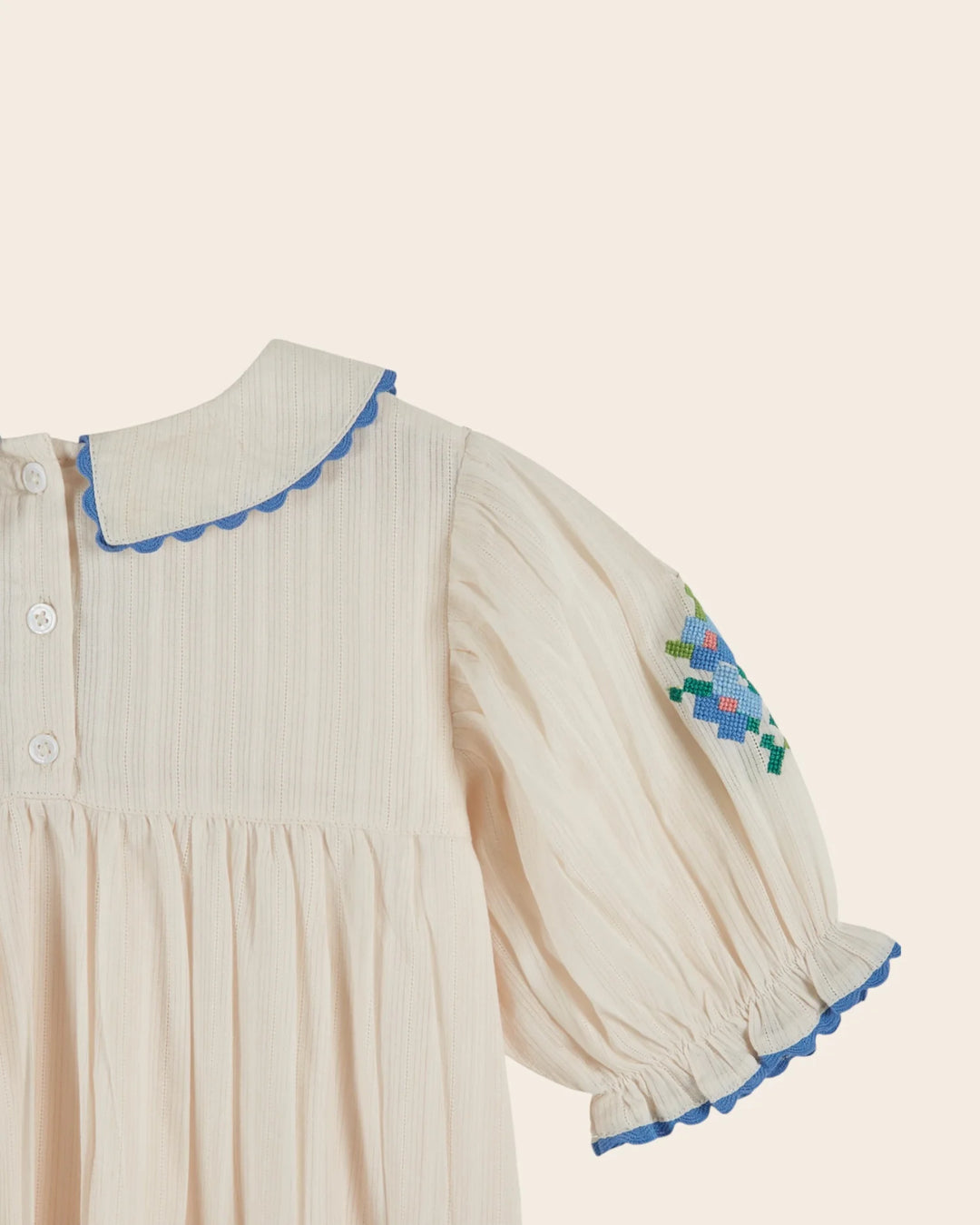 girls cream embroidered cotton dress with blue scalloped trim
