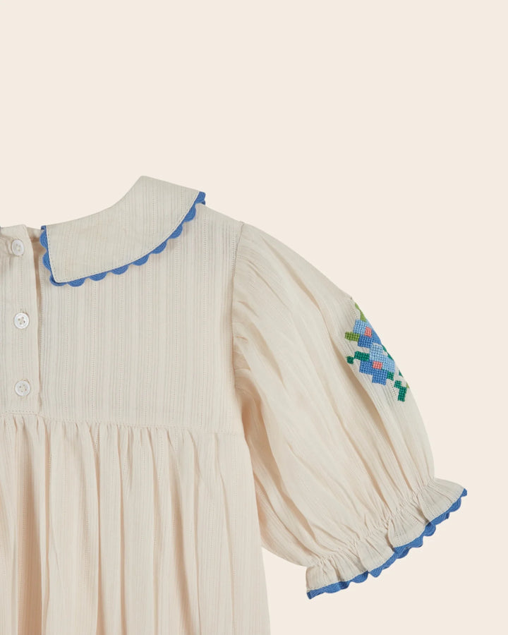 girls cream embroidered cotton dress with blue scalloped trim
