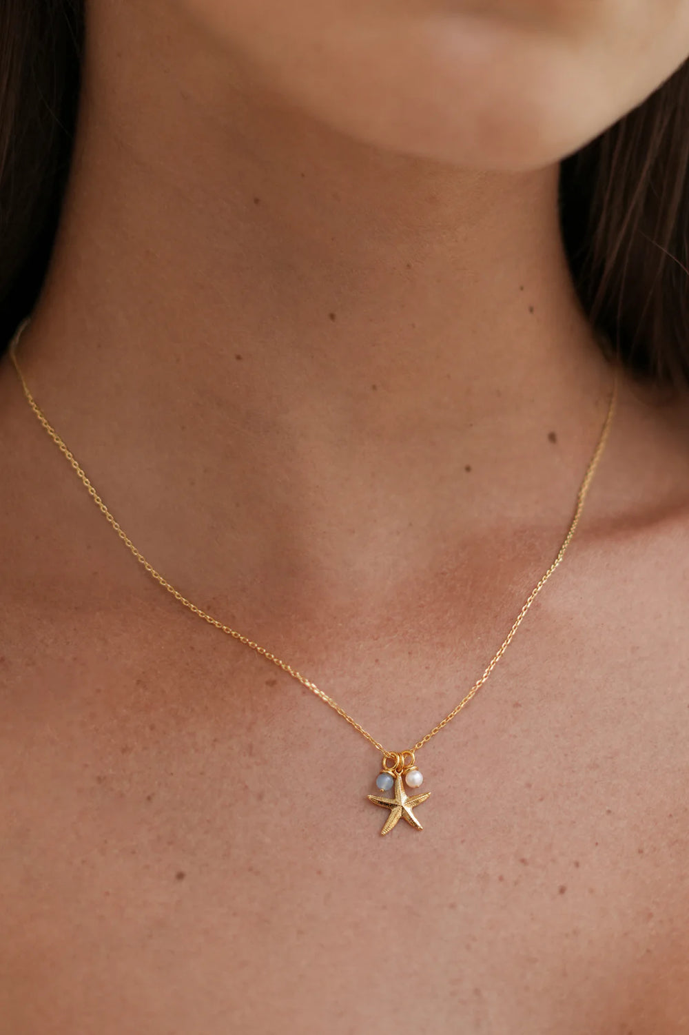 Estella Bartlett gold plated starfish charm necklace with pearl and blue agate details