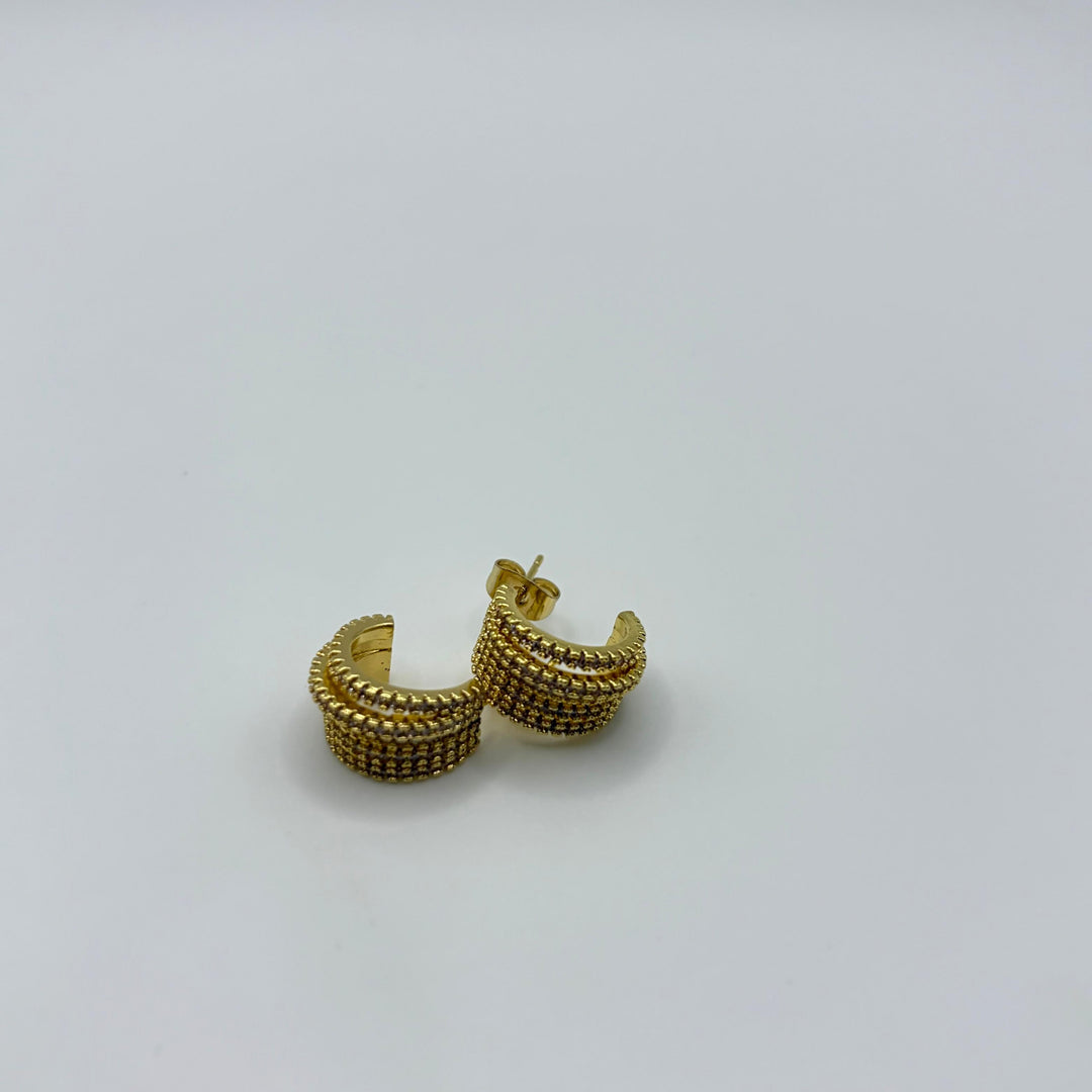 Habaha gold crystal huggie earrings with multi-row pavé detailing and polished gold finish on a white background