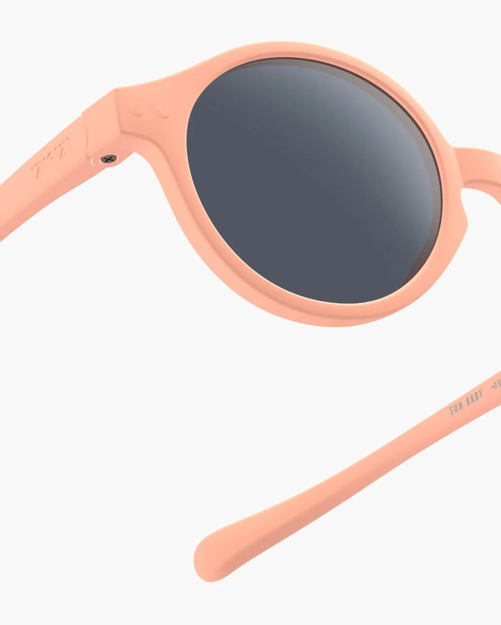 IZIPIZI Baby #D Apricot polarized sunglasses for toddlers aged 0–3 with a soft peach matte frame and grey lenses