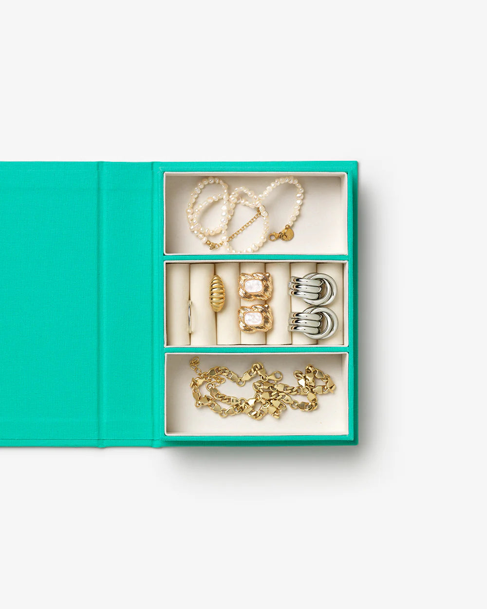 Turquoise jewellery box with book-inspired design and organised compartments for rings, necklaces and earrings