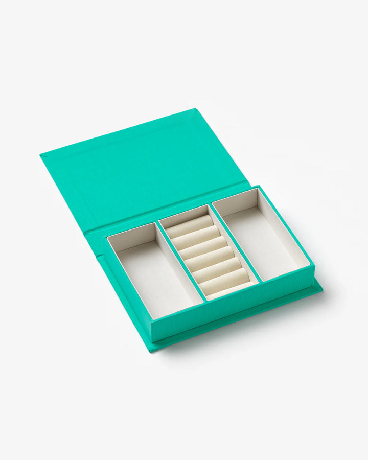Turquoise jewellery box with book-inspired design and organised compartments for rings, necklaces and earrings
