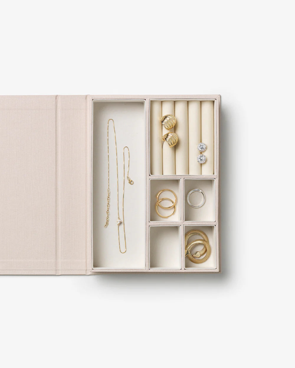 Beige jewellery box with book-inspired design, ring compartments and elegant storage for jewellery and keepsakes