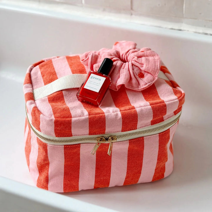 Rose in April Suki Vanity striped cosmetic case in pink and coral with zip closure.